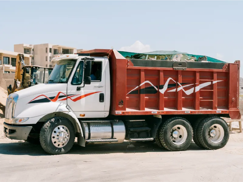 Camión de volteo International TranStar con caja de volteo roja en una obra de Los Cabos